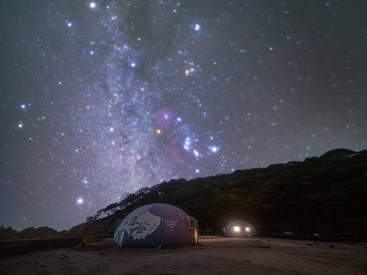 満天の星と島に設置されたドーム型テントの夜景